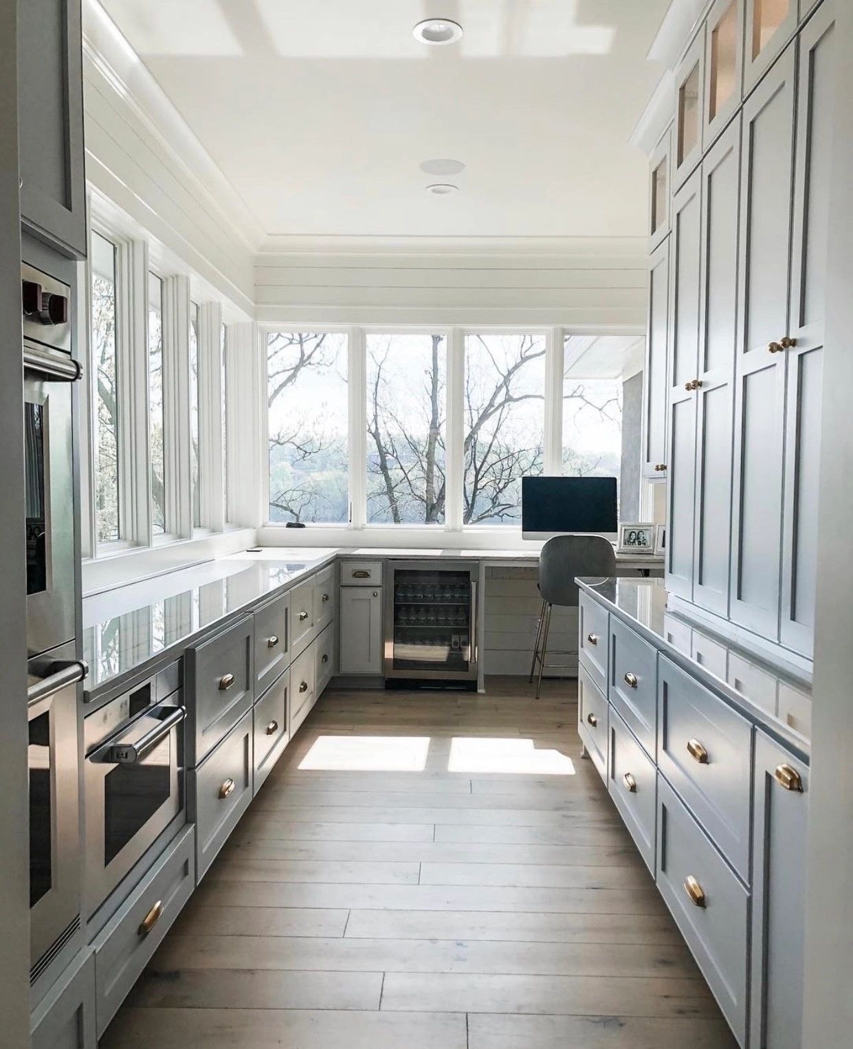 Modern kitchen hallway with white cabinetry and brass hardware